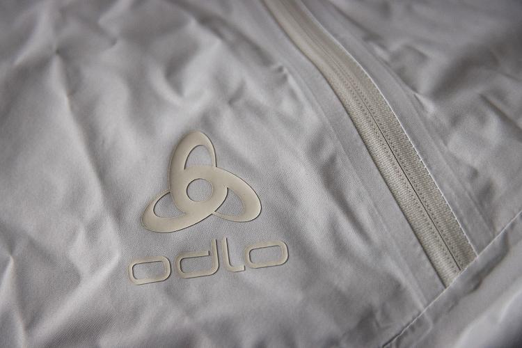 Logo et zip de la veste coupe vent Odlo Essentials 2.5L Logo et zip de la veste coupe vent Odlo Essentials 2.5L